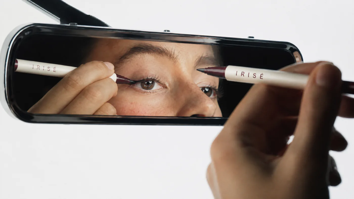 Une cliente Irisé devant le miroir, pendant un cours de maquillage en boutique